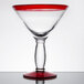 A clear glass with a red rim and base.
