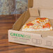 A slice of pizza in a GreenBox pizza box.