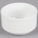 A Tuxton bright white china bouillon cup with an embossed white rim on a gray surface.