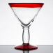 A clear martini glass with a red rim and base.