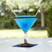 A Libbey martini glass with a blue drink and two straws.