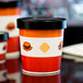 A close-up of a red and white striped Choice paper soup cup with a lid.