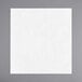 A flat-packed white Touchstone by Choice dinner napkin on a gray surface.