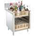 An Advance Tabco stainless steel glass rack storage cabinet on a counter with shelves of glasses and liquor bottles.