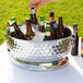 A Tablecraft Bali stainless steel beverage tub on a table outdoors.