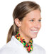 A woman in a chef's uniform smiling with a colorful pepper patterned bandana around her neck.