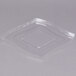 A clear plastic lid with a square cut out over a clear plastic bowl.