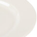 A close-up of an Elite Global Solutions Cottage Vintage California white plate with a white rim.