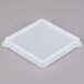 A clear square plastic lid on a white square plastic container.
