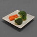 A square two-tone melamine plate with a piece of broccoli and carrots on it.