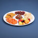 A white Elite Global Solutions Merced tray with compartments holding fruit and vegetables.