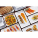 A group of rectangular white GET Midtown Melamine platters with food on them.