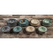 A group of Elite Global Solutions Mojave Vintage California Vanilla crackle melamine plates and bowls on a wood table.