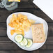 An Elite Global Solutions white irregular edge melamine plate with a sandwich and potato chips on it.