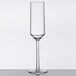 A clear Tritan plastic champagne flute with a stem on a table.