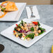 A white Elite Global Solutions square melamine plate with a salad on it.