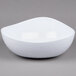A white triangle-shaped melamine bowl with a wavy design on it.
