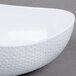 A white GET Coralline melamine bowl with a triangle shape and white rim.