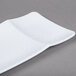 A white rectangular melamine platter with a curved design on the edge.