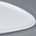 A white triangle shaped melamine plate with a coralline pattern on it.