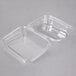A clear plastic 13 oz. Tamper-Evident Take Out Container with a lid open.