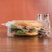A sandwich with meat and vegetables in a clear plastic tamper evident container.