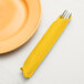 A yellow Creative Converting 3-ply paper dinner napkin with silverware in it.