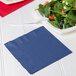A navy blue luncheon napkin with a fork and a plate of salad.