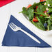 A plate of salad with strawberries and nuts with a navy blue Creative Converting luncheon napkin on the side.