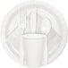 A white plate with a white Creative Converting luncheon napkin, plastic cup, spoon, and fork on it.