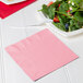 A plate of salad with a Classic Pink luncheon napkin on top.