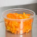 A Choice plastic deli container filled with chopped orange peppers.