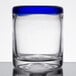 A close up of a Libbey rocks glass with a clear bottom and cobalt blue rim.