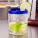 A Libbey Aruba rocks glass with ice and lime slices.