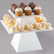 A white Cal-Mil square pedestal stand with cupcakes on it.