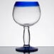 A clear Libbey Aruba cocktail glass with a stem and blue rim.