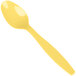 A Creative Converting yellow heavy weight plastic spoon on a white background.