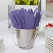 A bucket filled with purple Creative Converting plastic knives.