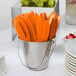 A bucket of Creative Converting Sunkissed Orange plastic utensils.