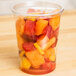 A Choice plastic container filled with fruit on a counter.