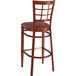 A red metal Lancaster Table & Seating Spartan Series bar stool with mahogany wood grain finish and burgundy vinyl seat.