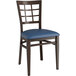 A Lancaster Table & Seating Spartan Series metal chair with dark walnut wood grain finish and navy vinyl cushion.
