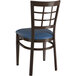 A Lancaster Table & Seating metal chair with dark walnut wood grain and a navy vinyl cushion.