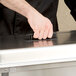 A person using a Vollrath Kool Touch handle to open a metal box.