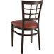 A Lancaster Table & Seating metal restaurant chair with dark walnut wood grain finish and burgundy seat.