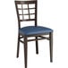 A Lancaster Table & Seating Spartan Series metal chair with a dark walnut wood grain finish and navy vinyl seat.