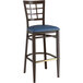 A Lancaster Table & Seating Spartan Series metal bar stool with navy vinyl seat and window back.