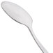 An Arcoroc stainless steel demitasse spoon with a white handle.