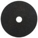 A 3M black circular floor pad with a hole in the middle.