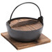 A black cast iron Japanese noodle bowl with a wooden lid and base.